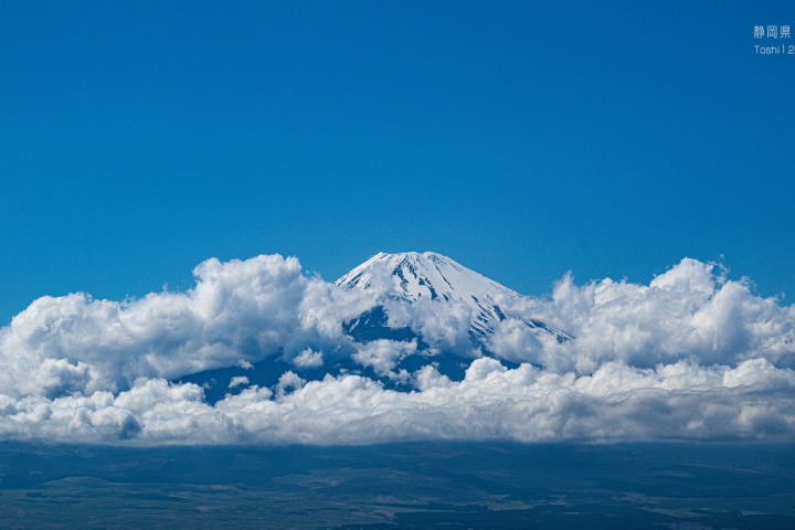藍天下，白雲環繞覆雪的富士山