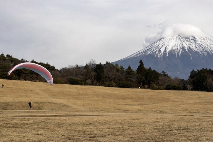 草地上的飛行傘與雲霧環繞的富士山