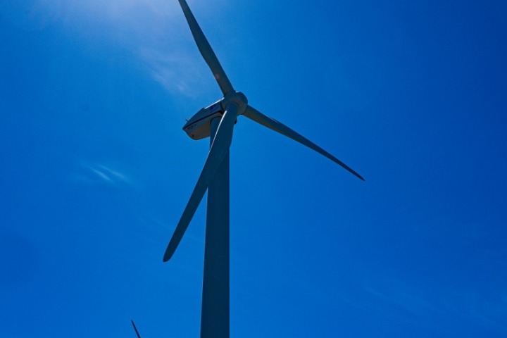 仰望深藍天空中的風力發電機與修長葉片